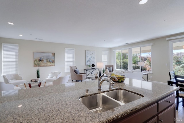 kitchen with a wealth of natural light, sink, and light stone counters