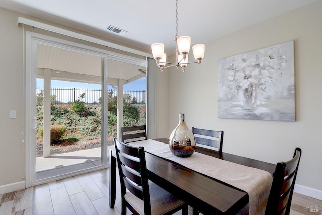 dining area with hardwood / wood-style floors and an inviting chandelier