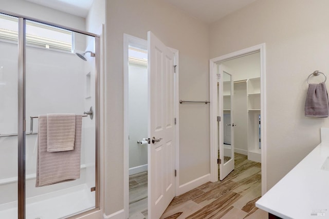 bathroom featuring vanity, hardwood / wood-style flooring, and a shower with shower door