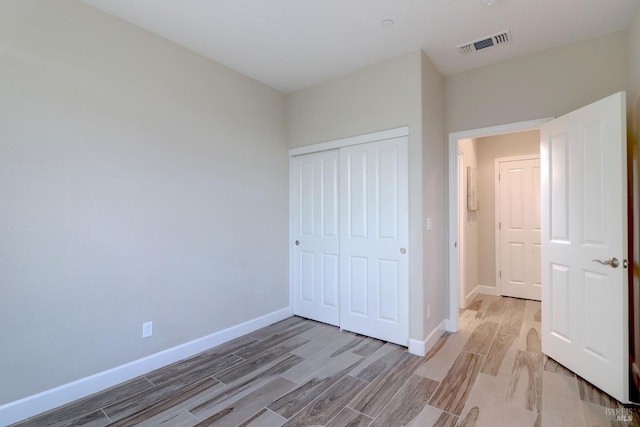 unfurnished bedroom featuring light hardwood / wood-style floors and a closet