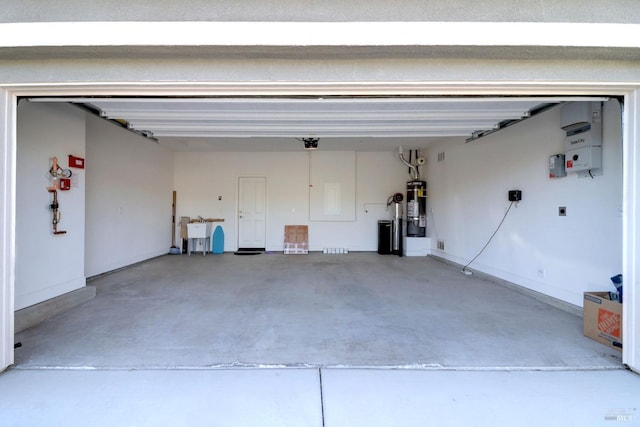 garage with a garage door opener, sink, and strapped water heater