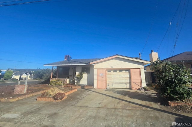 ranch-style home featuring driveway, a chimney, and an attached garage