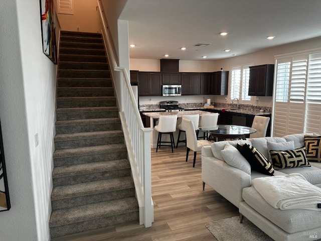 living room with light hardwood / wood-style floors and sink