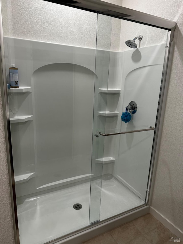 bathroom featuring a shower with shower door and tile patterned flooring