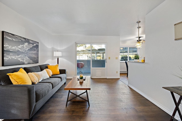 living room featuring ceiling fan and dark hardwood / wood-style flooring