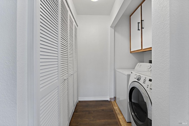 laundry area featuring cabinets, independent washer and dryer, and dark hardwood / wood-style flooring