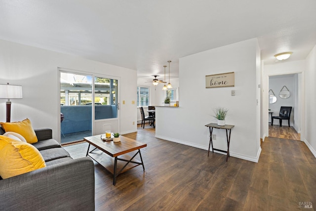 living room with ceiling fan and dark wood-type flooring