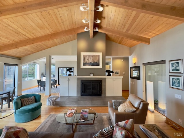 living room with light hardwood / wood-style flooring, vaulted ceiling with beams, and wooden ceiling