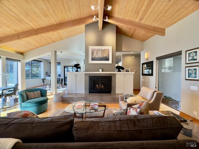 living room with vaulted ceiling with beams, light hardwood / wood-style flooring, wood ceiling, and a fireplace