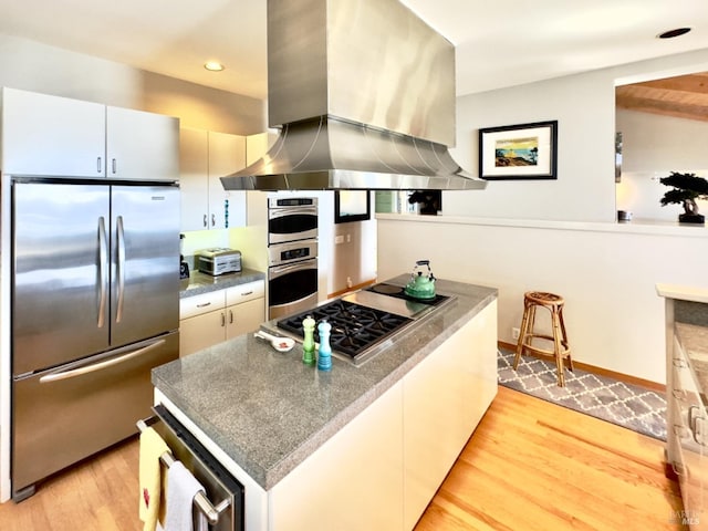 kitchen featuring light hardwood / wood-style flooring, white cabinets, stainless steel appliances, and island range hood