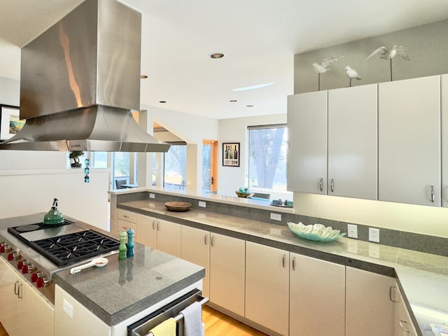 kitchen featuring stainless steel gas cooktop, light hardwood / wood-style flooring, wine cooler, and island range hood