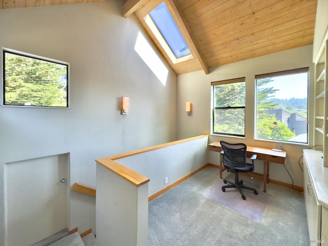 carpeted home office featuring vaulted ceiling with skylight and wood ceiling