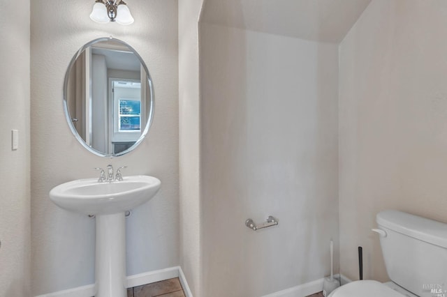 bathroom with toilet and tile patterned flooring