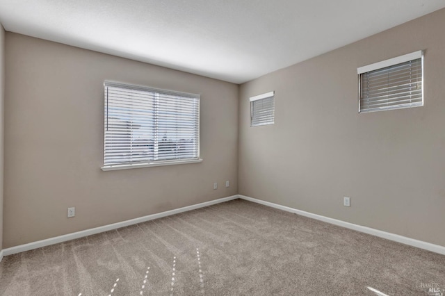 empty room with carpet flooring and baseboards