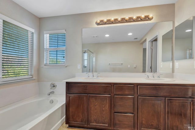 bathroom with a garden tub, visible vents, a sink, and double vanity