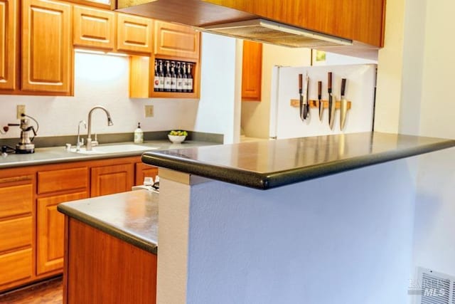 kitchen with a center island, sink, and white fridge