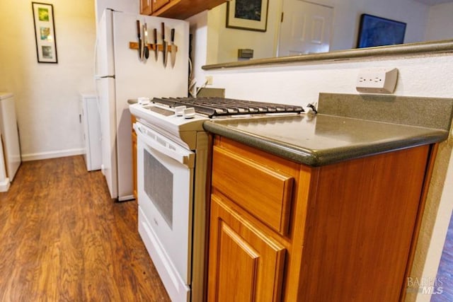 kitchen featuring white appliances and dark wood-type flooring