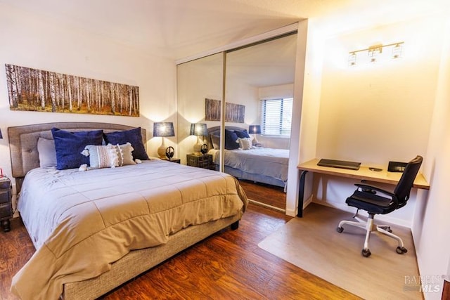 bedroom with dark hardwood / wood-style flooring and a closet