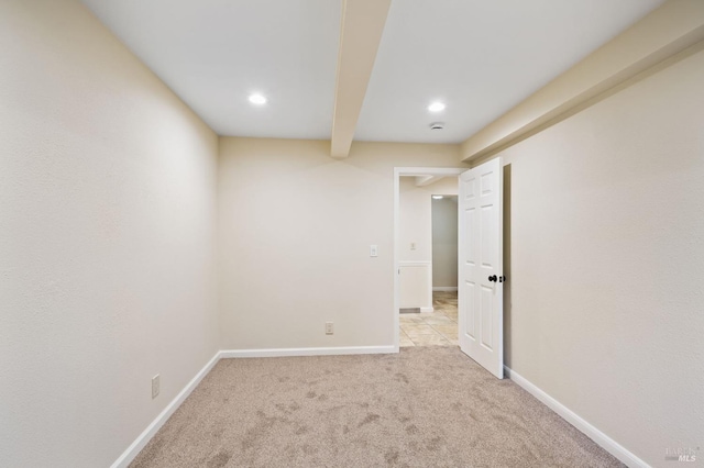 unfurnished room featuring beam ceiling and light carpet