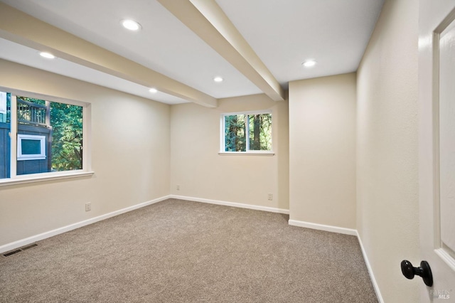 spare room with beamed ceiling and carpet flooring