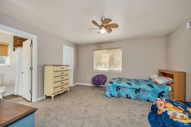 carpeted bedroom with multiple windows, ensuite bath, and ceiling fan