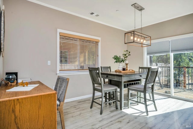 dining room with light hardwood / wood-style flooring, a chandelier, and crown molding