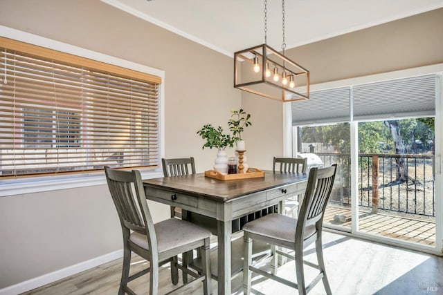 dining area with ornamental molding, a chandelier, and hardwood / wood-style floors