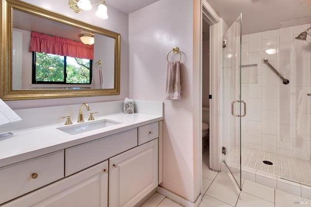 bathroom featuring tile patterned flooring, vanity, a shower with door, and toilet