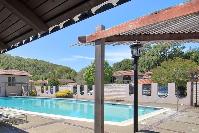 view of swimming pool with a patio and a pergola