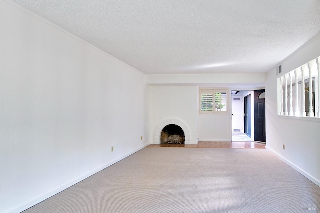 unfurnished living room with a textured ceiling, a brick fireplace, and carpet floors