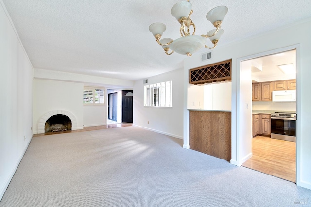 unfurnished living room with a brick fireplace, light colored carpet, a chandelier, and a textured ceiling