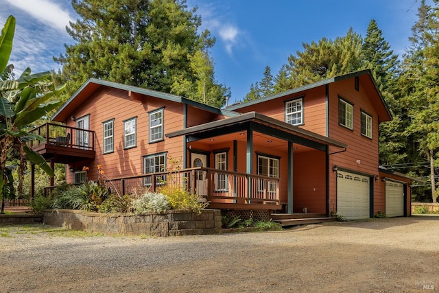 view of front of house with covered porch, a balcony, and a garage