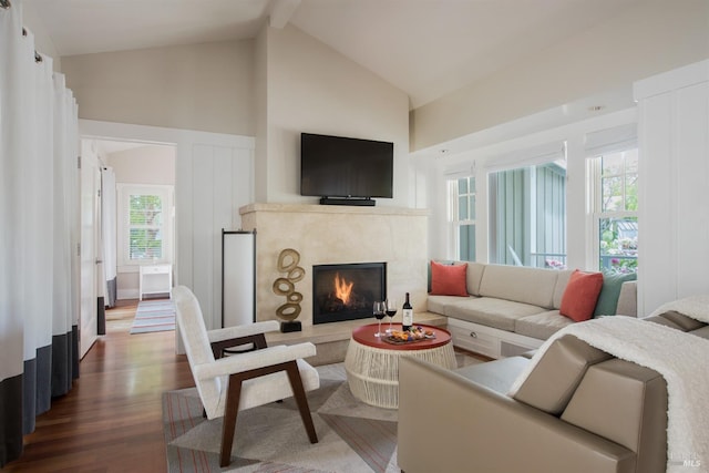 living room with beam ceiling, hardwood / wood-style floors, and high vaulted ceiling