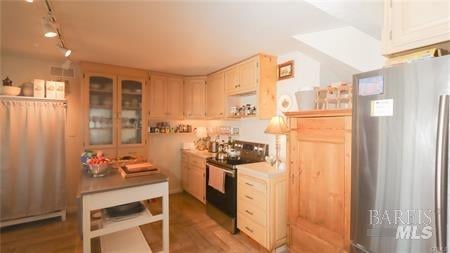 kitchen featuring light brown cabinetry, hardwood / wood-style flooring, appliances with stainless steel finishes, and track lighting