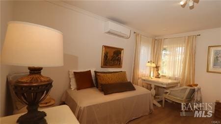 bedroom featuring a wall unit AC and hardwood / wood-style flooring