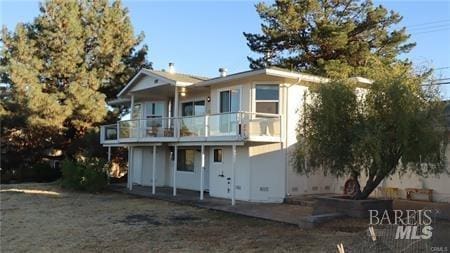 back of house with a patio and a balcony