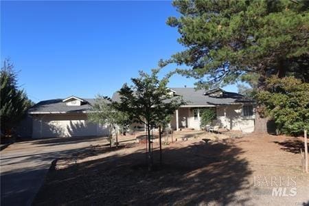 view of property hidden behind natural elements featuring a garage