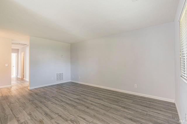 unfurnished room featuring dark hardwood / wood-style flooring and a healthy amount of sunlight