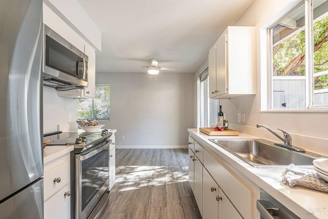 kitchen with white cabinets, plenty of natural light, sink, and stainless steel appliances