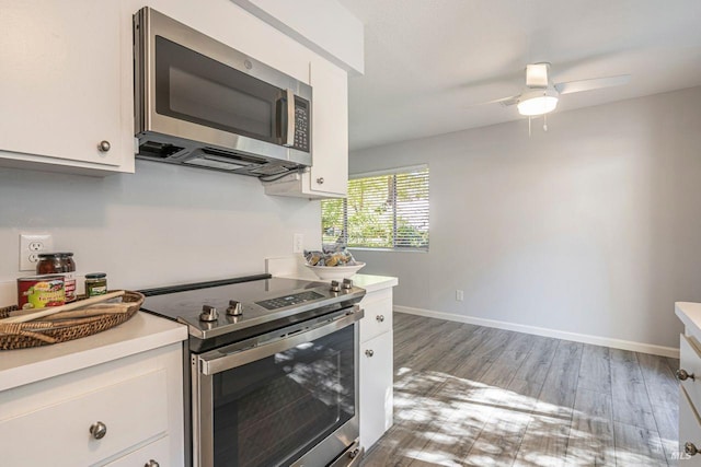 kitchen with white cabinets, stainless steel appliances, ceiling fan, and light hardwood / wood-style floors