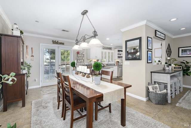 dining room featuring french doors, crown molding, and sink