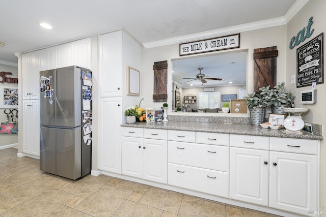 kitchen featuring crown molding, ceiling fan, a barn door, white cabinetry, and stainless steel refrigerator