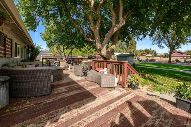 deck with outdoor lounge area, a lawn, and fence