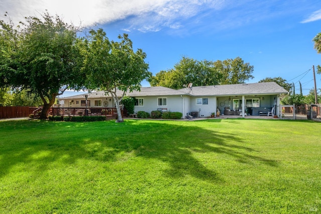 rear view of house featuring a patio area, fence, and a yard