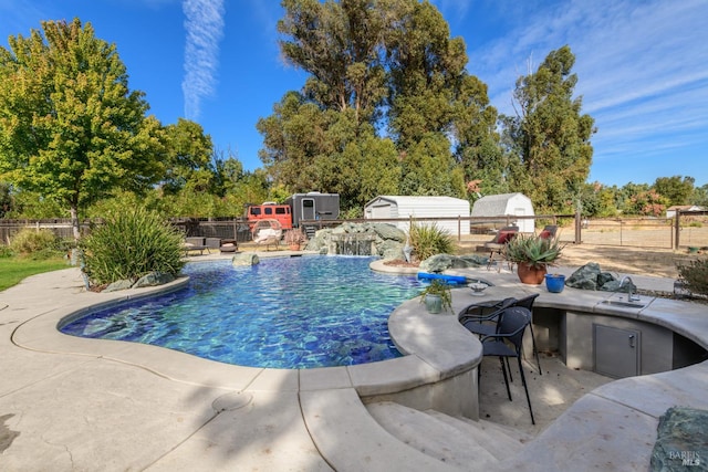 view of swimming pool featuring pool water feature and a patio area