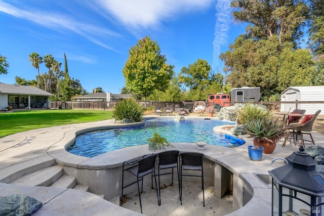 view of swimming pool with an outdoor structure, fence, a storage shed, a fenced in pool, and a lawn