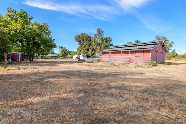 view of yard featuring an outbuilding and fence