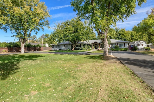 view of yard with driveway and fence
