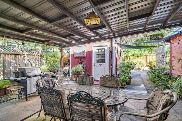 view of patio with a storage shed and a grill