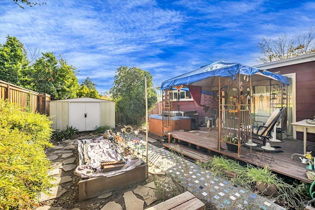 wooden terrace featuring a hot tub and a shed